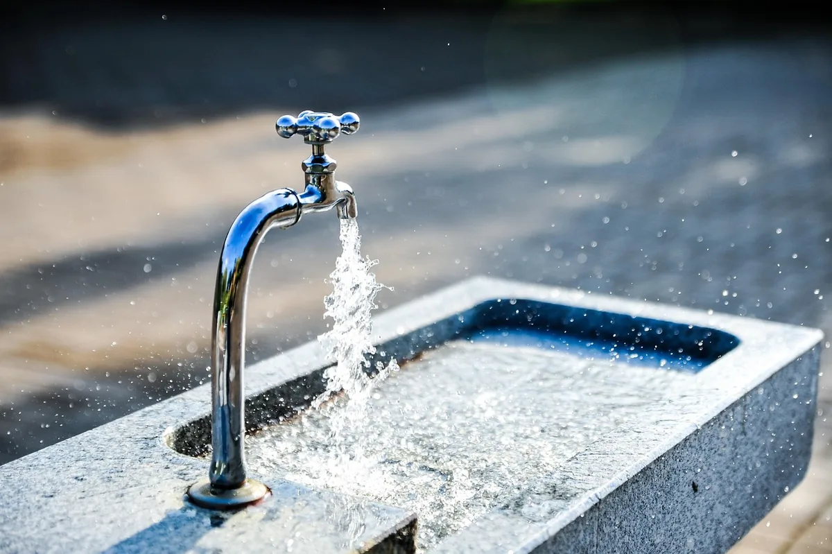 Eau coulant d’un robinet extérieur dans une vasque