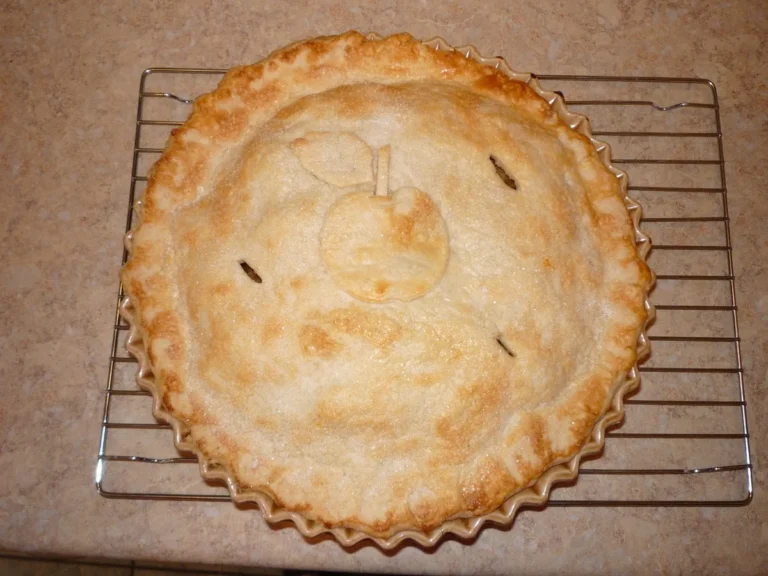 Tarte aux pommes maison dorée posée sur une grille