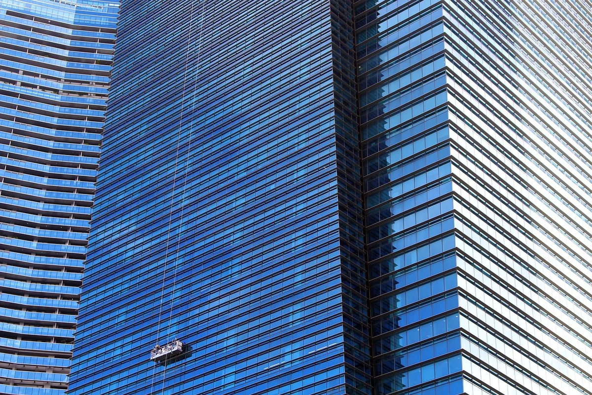 Laveur de vitres professionnel sur une façade vitrée